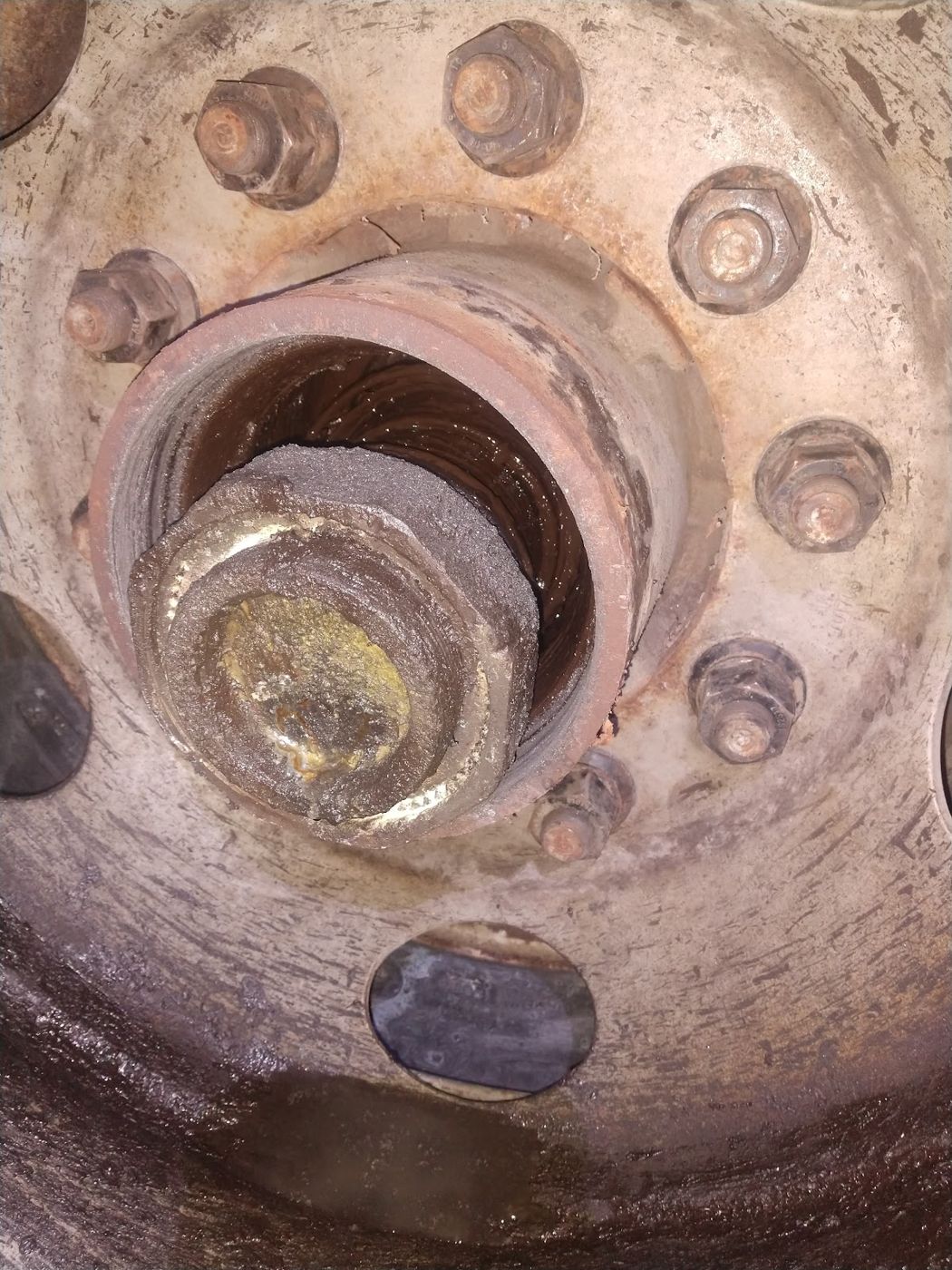 A wheel end with the hub cap off showing the axle nut