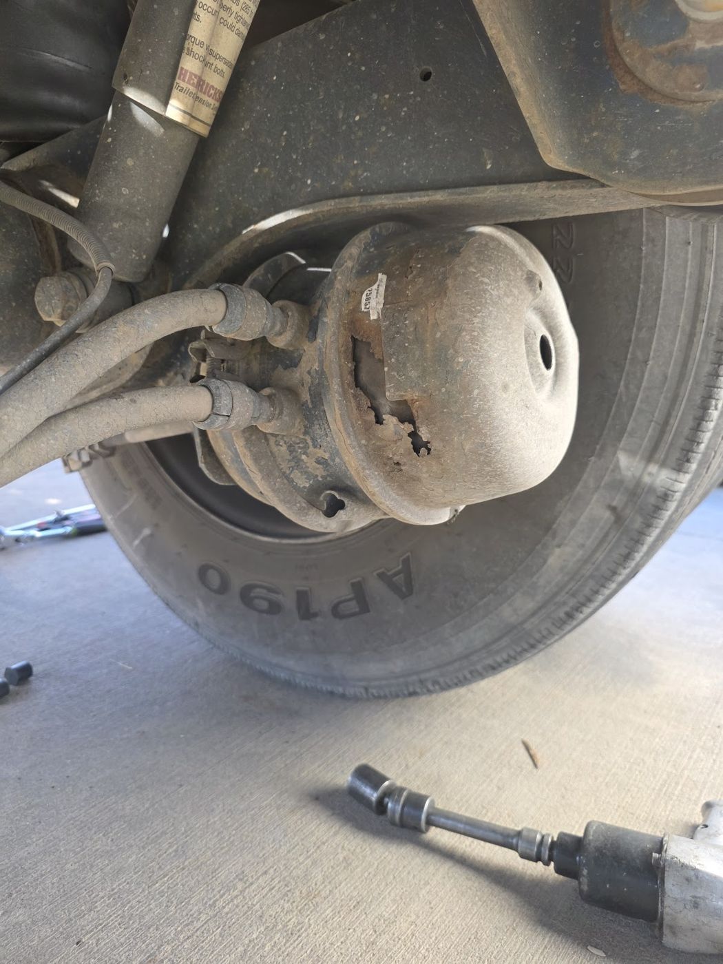 A truck brake chamber and tire seen from underneath