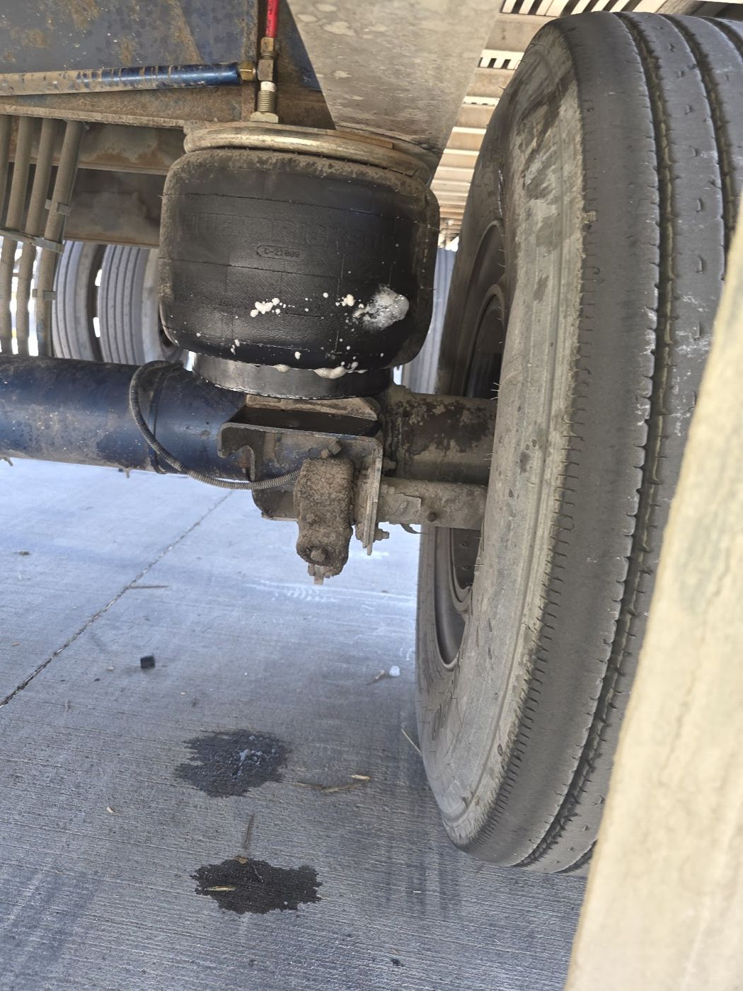 A truck air spring above the axle next to a tire