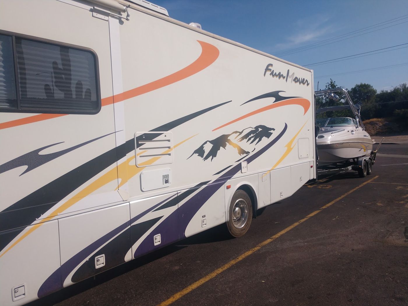 An RV with its trailer parked in a lot