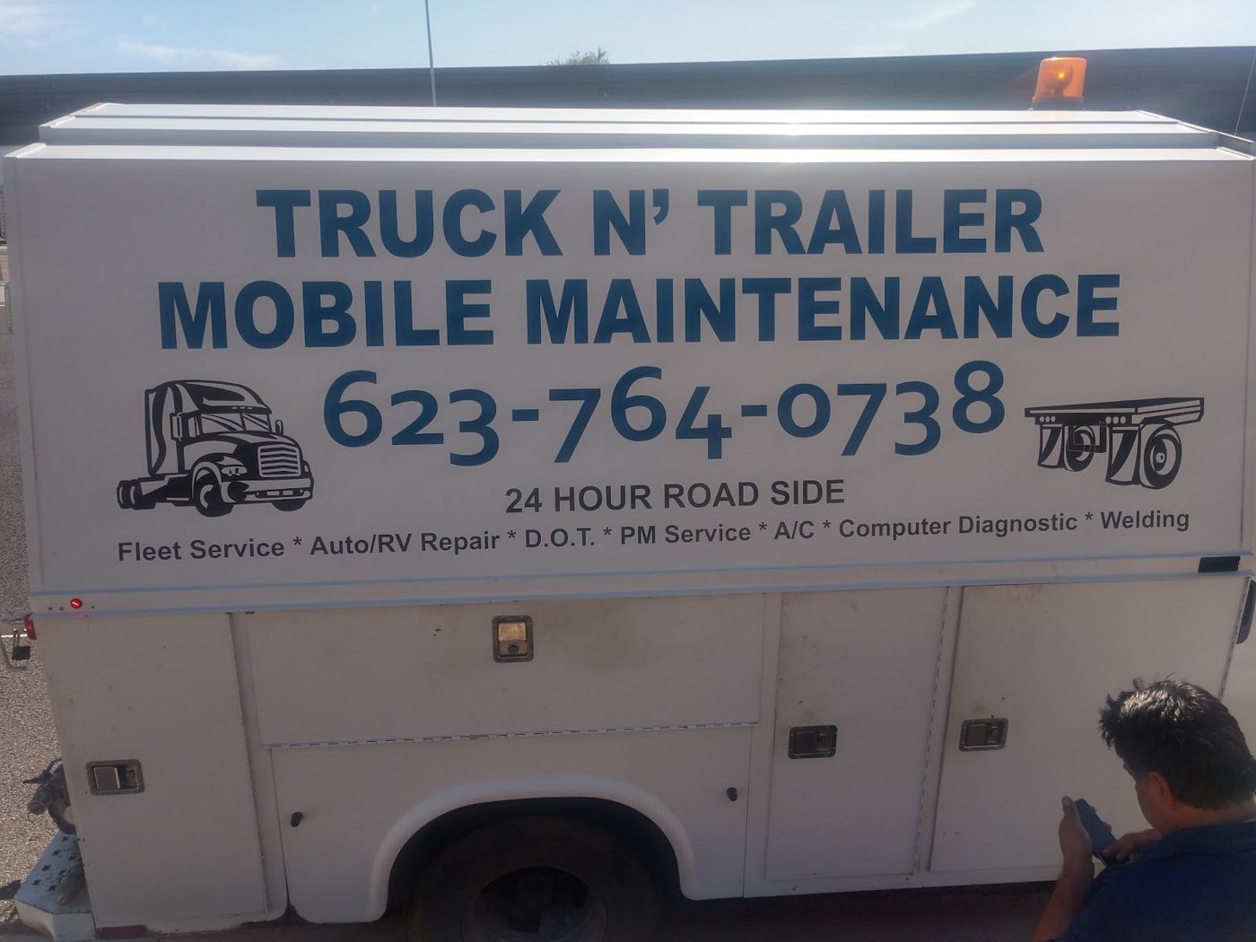The side of the service van lettered Truck N' Trailer Mobile Maintenance with 24 hour road side